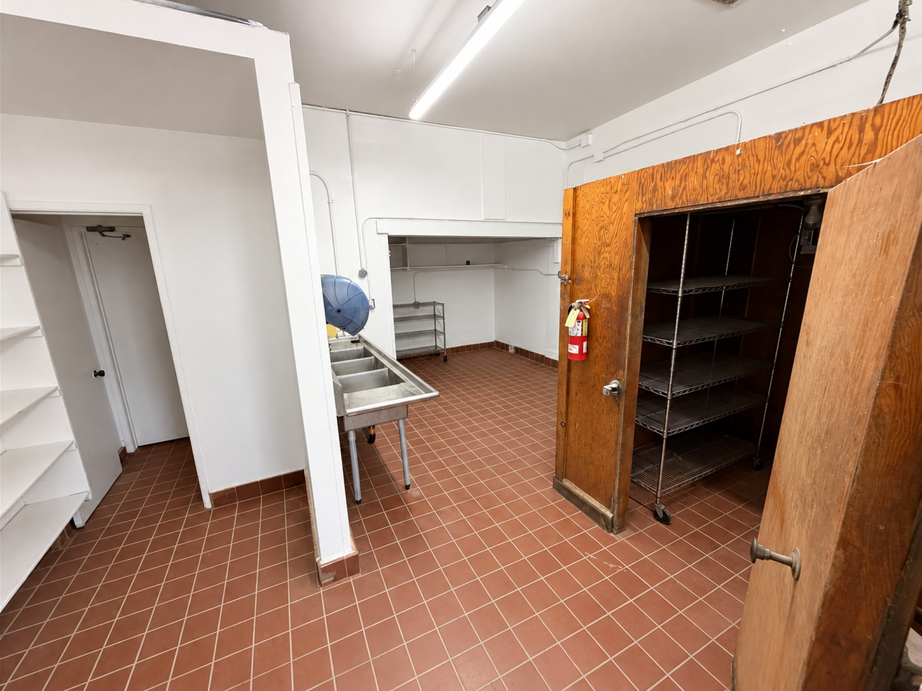 Back-of-house area with three-compartment sink and shelving